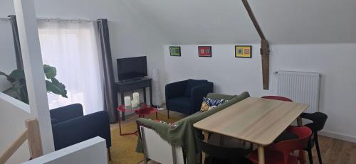 un salon avec une table et des chaises dans l'établissement Gîte, à Vigneux-de-Bretagne