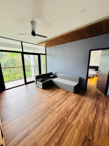 a living room with a couch and wooden floors at AYD-IN BY GREENLEAVES Resort in Vythiri