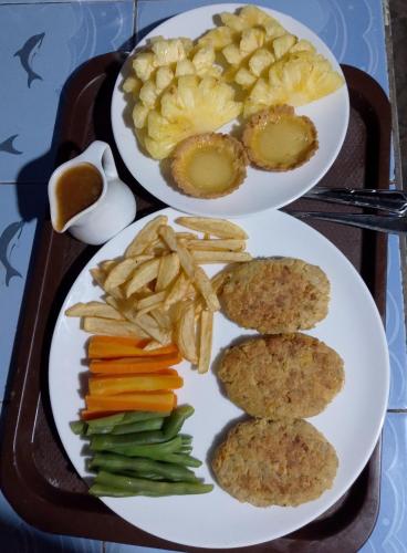 a tray with two plates of food with vegetables and meatballs at Naca Homestay in Manado