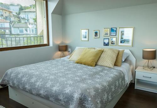 een slaapkamer met een bed met twee lampen en een raam bij Panoramic Sea-View I 2-Bedroom Flat with Terrace by Flat Manаger in Balchik