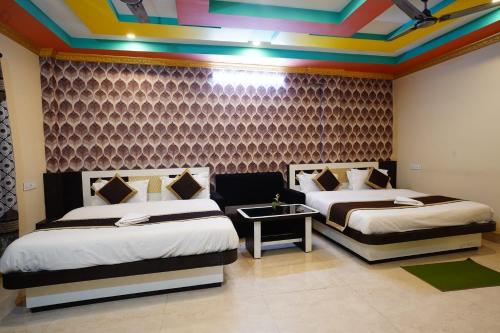 two beds in a room with a colorful ceiling at Tirupati Lodge NJP in Siliguri