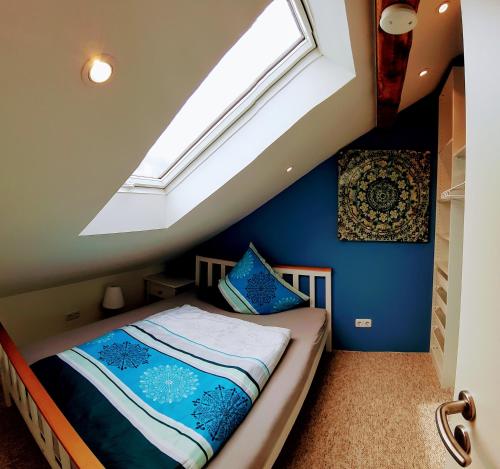 a attic bedroom with a bed with a skylight at ApartmentHotel Vollumen in Redwitz an der Rodach