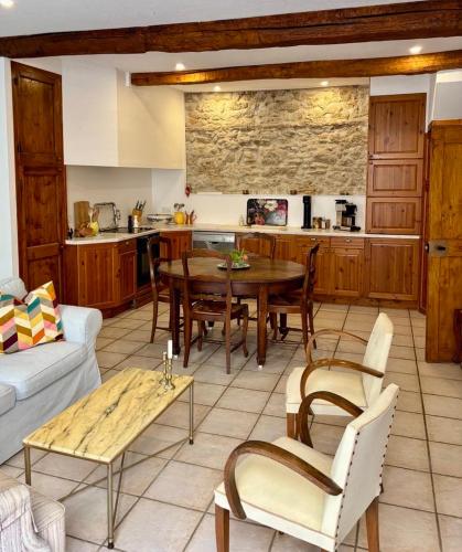 une cuisine et un salon avec une table et des chaises dans l'établissement Well equipped village house close to historic centre - Pézenas, à Pézenas