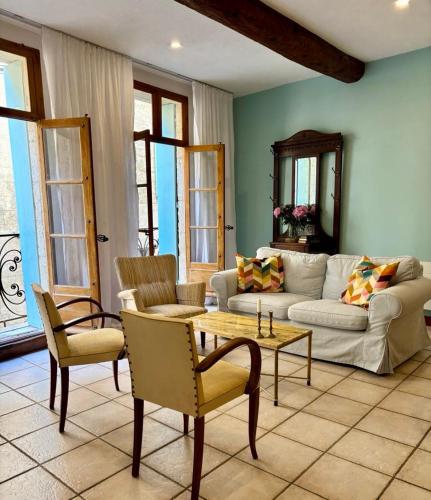 un salon avec un canapé, une table et des chaises dans l'établissement Well equipped village house close to historic centre - Pézenas, à Pézenas