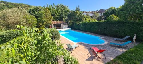 an overhead view of a swimming pool with two chairs and a table at Maison avec piscine entre garrigue et Cévennes in Cazilhac