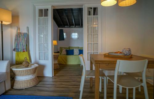 una stanza con tavolo e sedie e una camera da letto di GuestReady - OceanFront Lookout House a Ponta Delgada