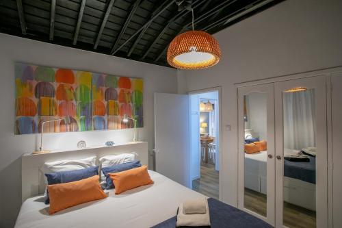a bedroom with a bed with orange pillows and a painting at GuestReady - OceanFront Lookout House in Ponta Delgada