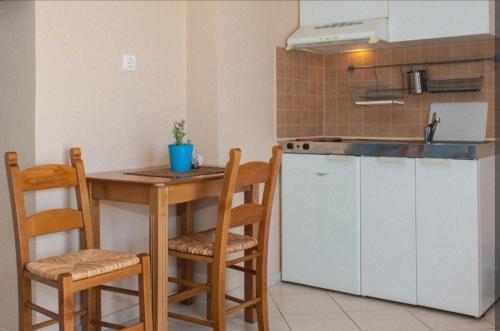 a kitchen with a counter and a table and chairs at Elena studio 2 in Vouvás