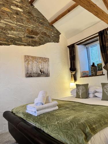 a bedroom with a bed with towels on it at Nuthatch by Together Travel - Luxury Cornish Countryside Retreat in Bodmin