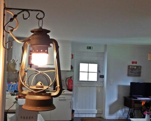 a light hanging from the ceiling in a room at Ninho do Cedro - Azorean tranquility in Ponta Delgada