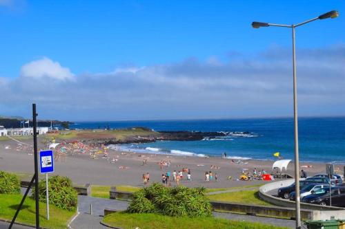 a group of people on a beach near the ocean at Ninho do Cedro - Azorean tranquility in Ponta Delgada