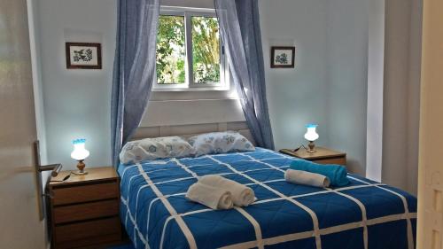 ein Schlafzimmer mit einem blauen Bett mit Handtüchern darauf in der Unterkunft Ninho do Cedro - Azorean tranquility in Livramento