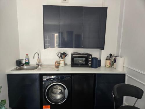 a kitchen with a washing machine and a microwave at Newly Built Studio Apartment in Weston