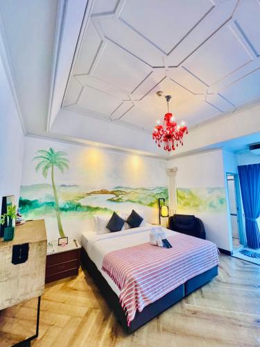 a bedroom with a large bed and a chandelier at Yuu Hotel Ubon Ratchathani in Ubon Ratchathani