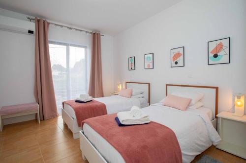 a hotel room with two beds and a window at GuestReady - 9C House in São Vicente Ferreira
