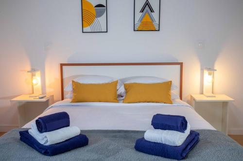 a bedroom with a bed with blue and yellow pillows at GuestReady - 9C House in São Vicente Ferreira
