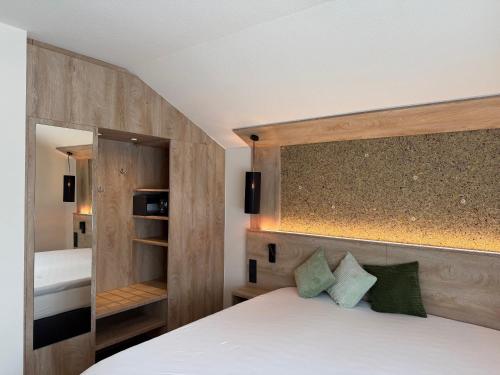 a bedroom with a bed with a wooden headboard at Hotel Restaurant Brinckwirth in Ochtrup