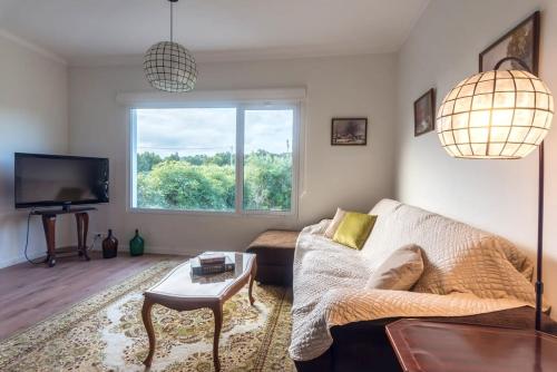 a living room with a couch and a window at Quinta do Solar perfect for families in Ponta Delgada