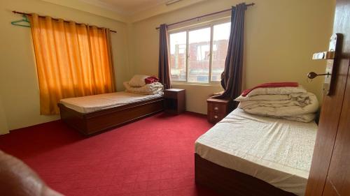 ein kleines Zimmer mit zwei Betten und einem Fenster in der Unterkunft Tise Homestay in Bālāju