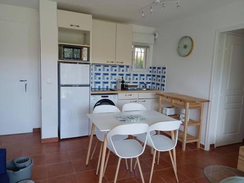 une cuisine avec une table et des chaises dans une cuisine dans l'établissement Le ciel, le soleil et la mer !, à Sainte-Maxime