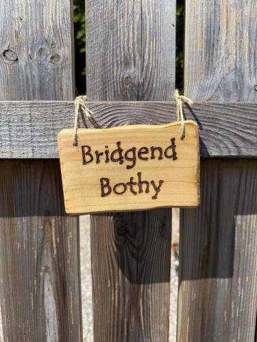 a wooden sign hanging on a wooden fence at Bridgend Bothy in Drumnadrochit