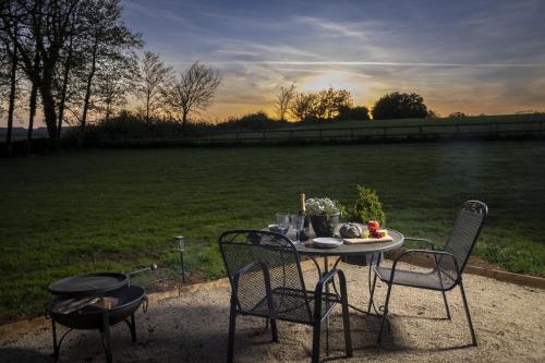 a table and chairs with a table and a field at The Cotswold Nest in Moreton in Marsh