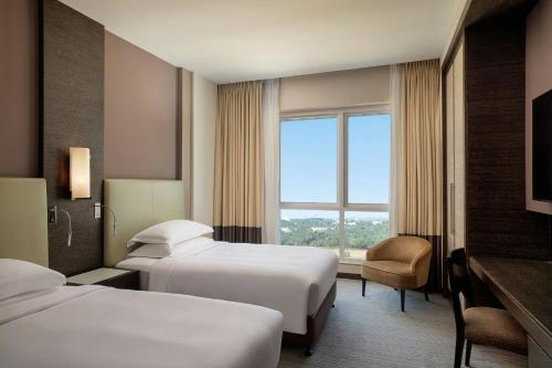 a hotel room with two beds and a window at Four Points by Sheraton Al Ain in Al Ain