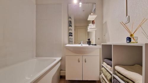 a white bathroom with a sink and a bath tub at Maison Solèna in Gallargues-Le-Montueux