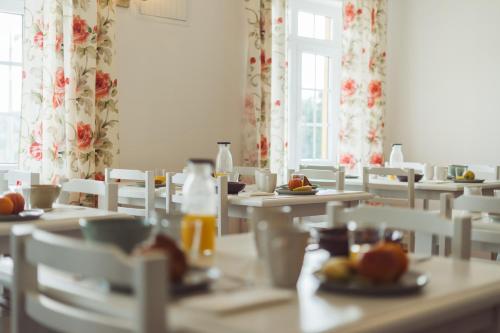 a dining room with tables and chairs with food on them at Conde Távora in Atouguia da Baleia