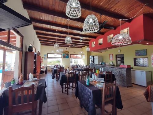 a restaurant with tables and chairs and chandeliers at Altos de Amaicha Posada Boutique in Amaicha del Valle