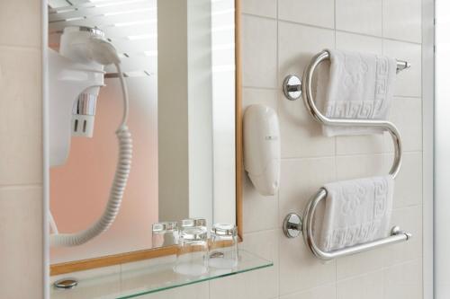 a shower with a phone and a mirror in a bathroom at Art City Inn in Vilnius