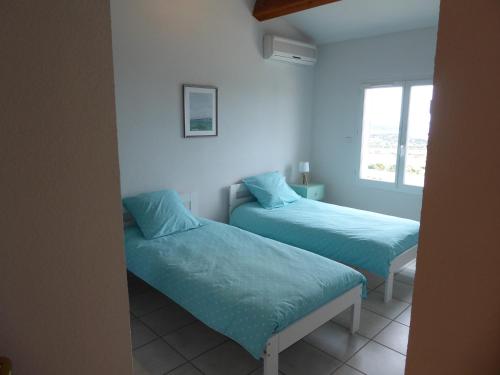 une chambre avec deux lits et une fenêtre dans l'établissement Vue panoramique imprenable sur la Méditerranée, à Fitou