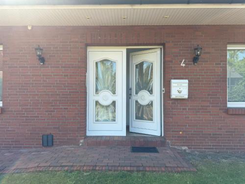 a brick house with two white doors on it at LlVINQ 11 in Emstek
