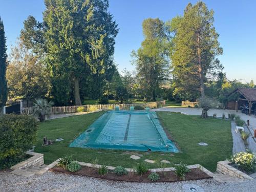 an empty swimming pool in the middle of a yard at La Grande Maison in Saint-Mars-dʼOutillé