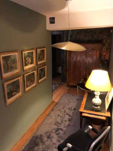 a living room with a table and a lamp at La Grande Maison in Saint-Mars-dʼOutillé