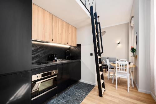 une cuisine avec des appareils noirs et une salle à manger dans l'établissement 5mn Monaco - Cosy appartement avec Mezzanine - DH, à Beausoleil