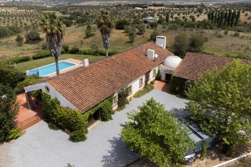 an aerial view of a house with a swimming pool at Courela da Azinheira - Country Guesthouse in Lavre
