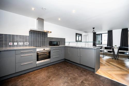 a kitchen with stainless steel appliances and a living room at Staycity Aparthotels Liverpool City Centre in Liverpool