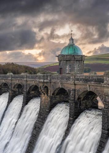 a bridge over a waterfall with a tower at Llanidloes Townhouse-pet-friendly-sleeps 7-Mid Wales in Llanidloes