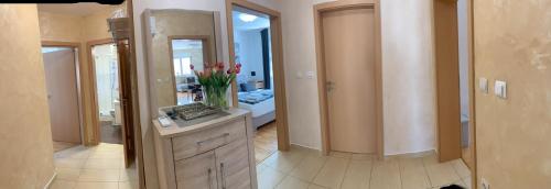a bathroom with a vanity with a mirror and flowers at apartman Lavanda in Valbandon