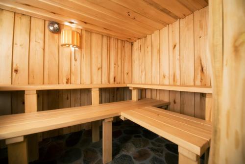 a wooden sauna with a bench in it at Dworek Króla Stanisława - Apartament Jaśminowy in Węgorzewo