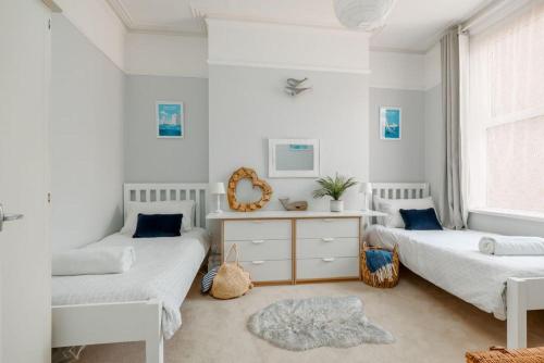 a bedroom with two beds and a window at Balcony Apartment in Swanage