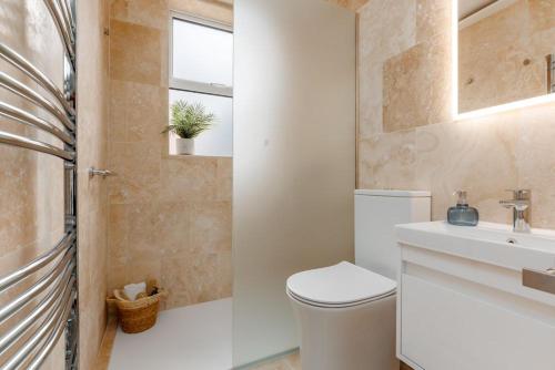 a bathroom with a toilet and a sink and a window at Balcony Apartment in Swanage