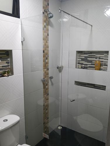 a bathroom with a glass shower with a toilet at Hospedaje samfer in Envigado