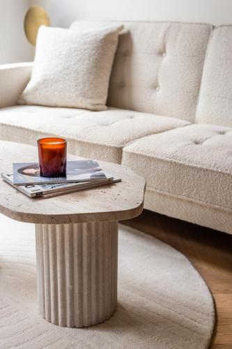 une table basse avec une tasse dessus à côté d'un canapé dans l'établissement Luxury-1BR#Louvre#Saint-Honore#Palais-Royal, à Paris