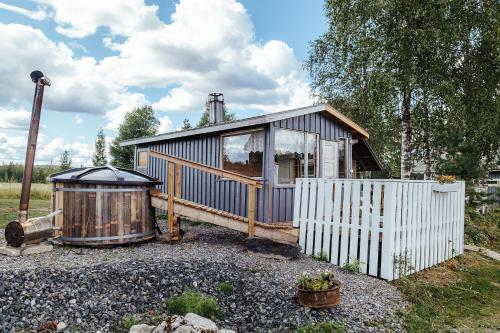a small house with a fence next to it at Elämysmajoitus Piisaminpesä in Iisalmi