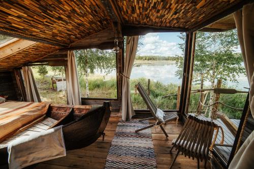 a room with hammocks and a view of a river at Elämysmajoitus Piisaminpesä in Iisalmi