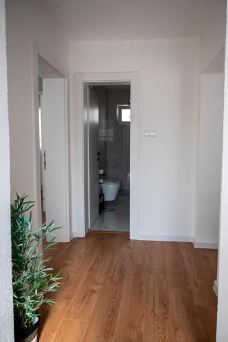 an empty room with white walls and wooden floors at Stan na dan Gornji Vakuf Uskoplje in Gornji Vakuf