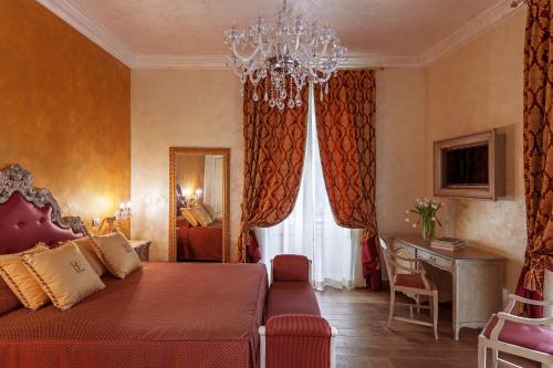 a bedroom with a red bed and a chandelier at Relais Empire in Verona