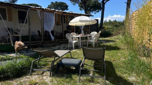 a patio with a table and chairs and an umbrella at Evasion balneo Fréjus in Fréjus
